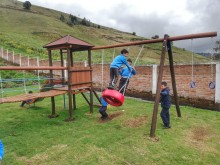 Der Spielplatz hat eine Rutsche und Schaukeln