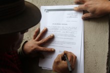 Manuel Quinche Gualán firma il documento di proprietà del bagno