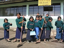 Los niños se esfuerzan por limpiar el patio de la escuela